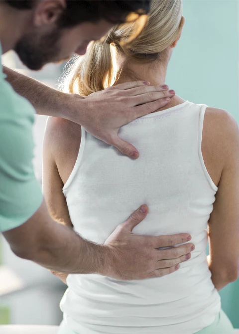 Manual spinal assessment performed by a clinician applying guided pressure along the upper back.